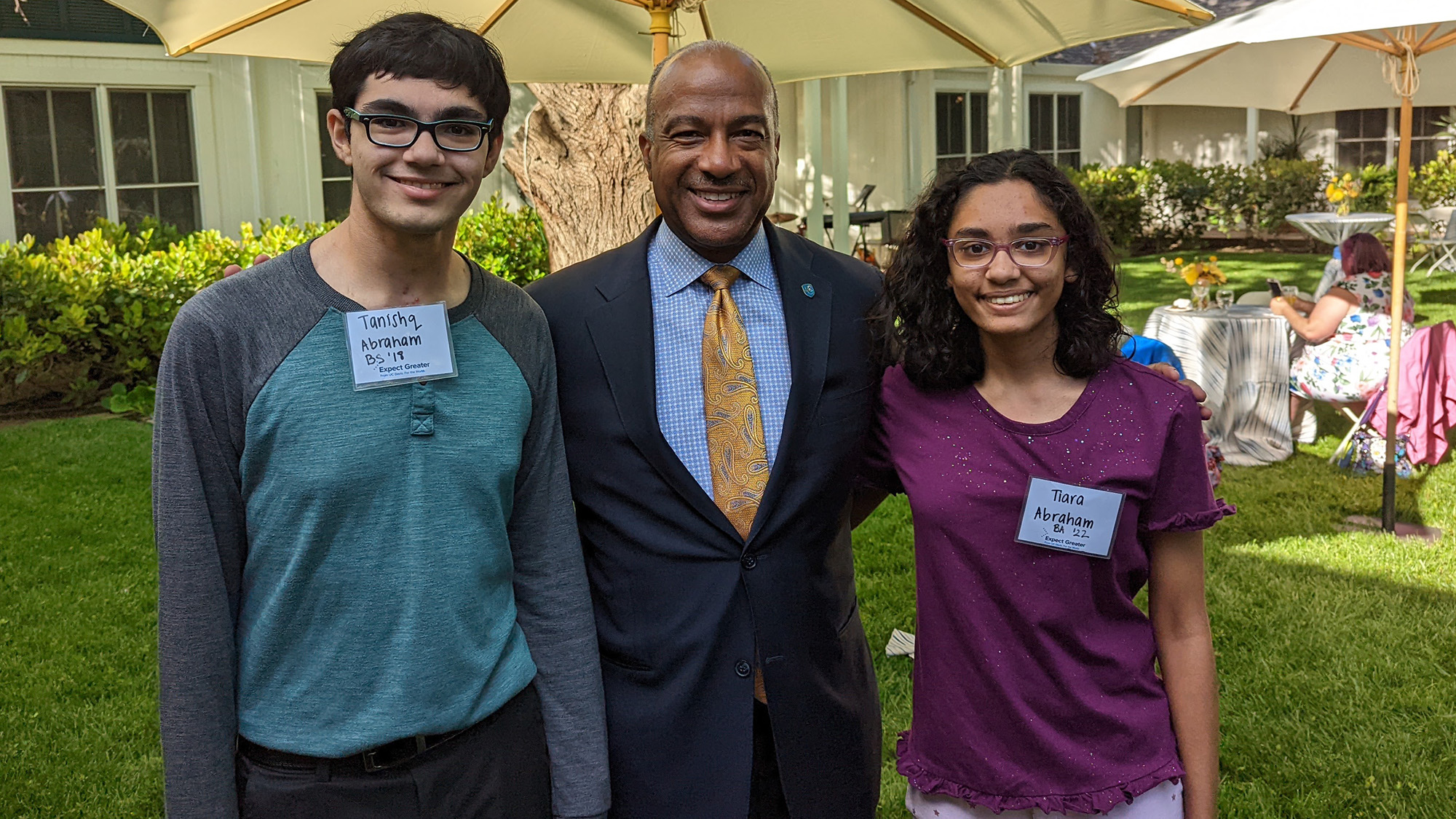 Tanishq Abraham, Chancellor Gary S. May, and Tiara Abraham pose for a photo.