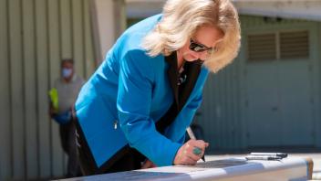 Provost Mary Croughan signing a beam at the Teaching and Learning Center