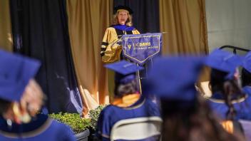 Provost Mary Croughan in commencement regalia speaking at a podium