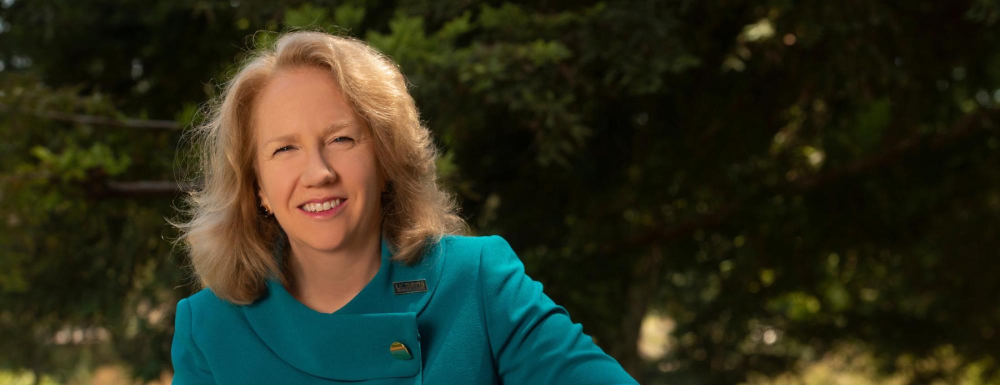 Provost Mary Croughan sitting outside wearing teal suit