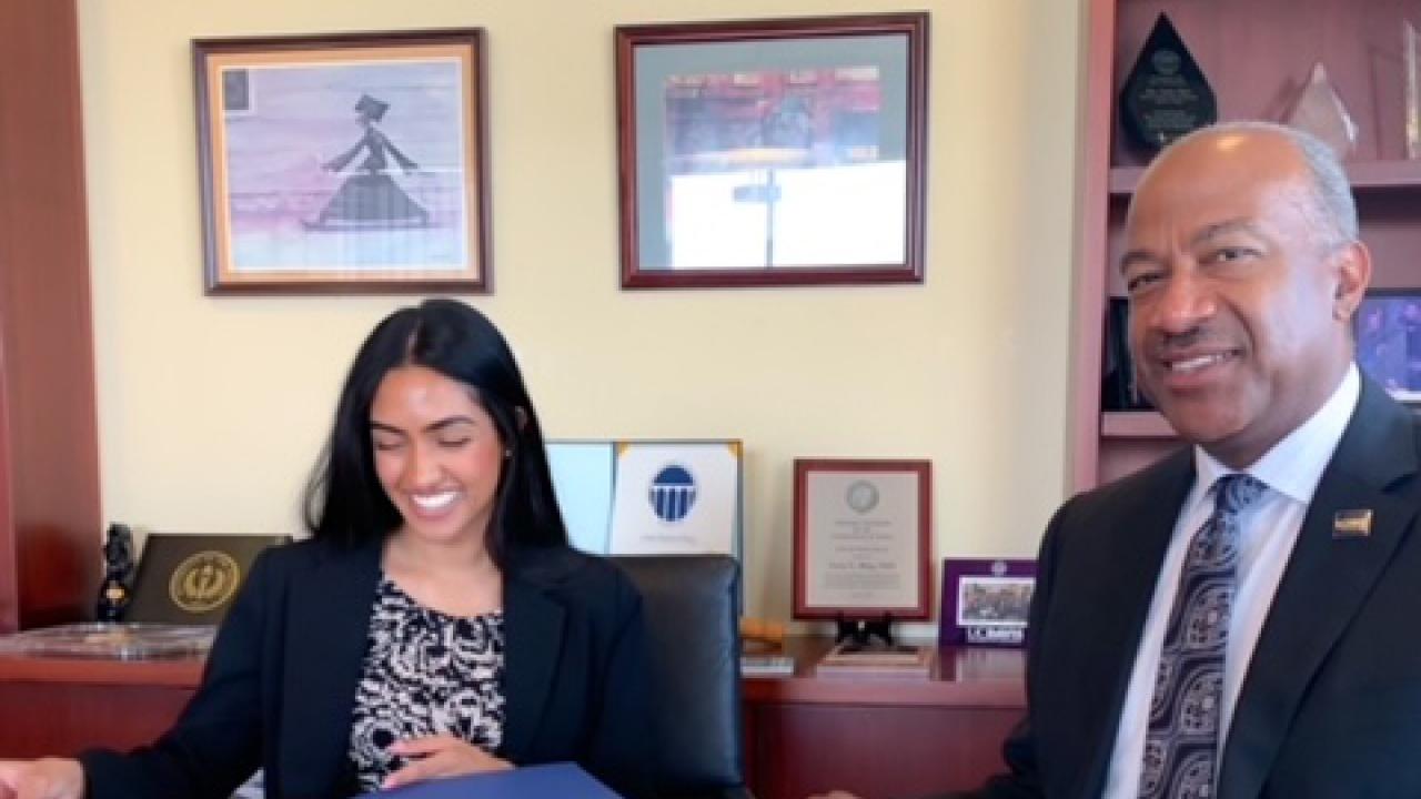 Two people sit at an office table