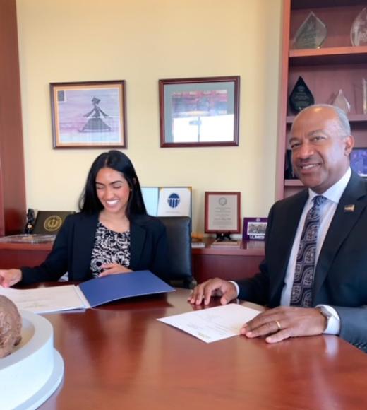 Two people sit at an office table